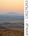 Scenic mountain sunset, golden hour over rolling plains, vibrant orange sky and peaceful natural landscape 136276263