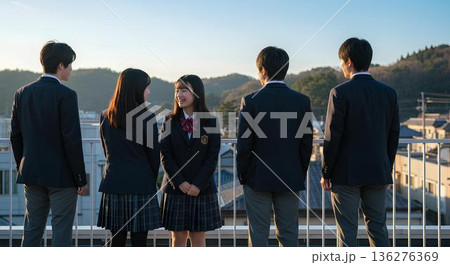 夕暮れの屋上で笑顔を交わす高校生たち。友情と青春を感じる学校風景。 夕暮れの屋上で笑顔を交わす高校生たち。友情と青春を感じる学校風景。 136276369