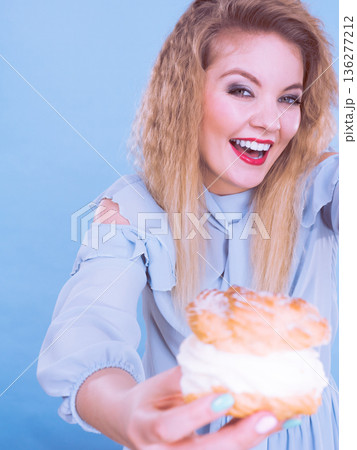 Funny woman holds cream puff cake 136277212
