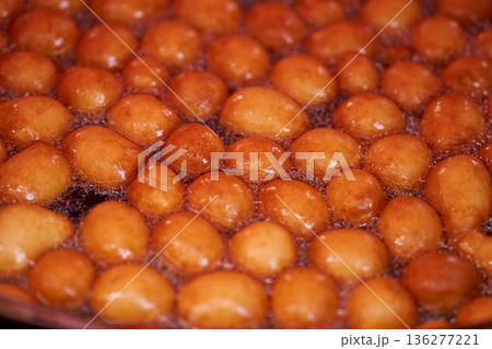 Donuts or doughnuts are made from a mixture of flour, sugar, egg yolks, yeast, and butter. Ball shaped, powdered sugar on a stacked donut 136277221