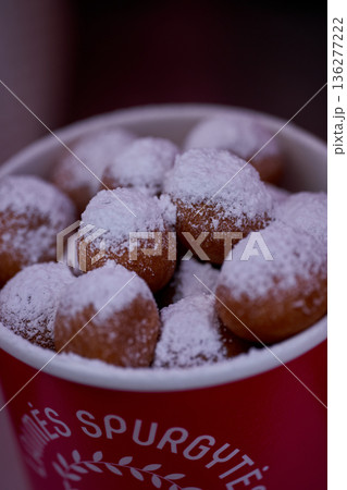 Donuts or doughnuts are made from a mixture of flour, sugar, egg yolks, yeast, and butter. Ball shaped, powdered sugar on a stacked donut 136277222