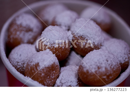 Donuts or doughnuts are made from a mixture of flour, sugar, egg yolks, yeast, and butter. Ball shaped, powdered sugar on a stacked donut 136277223