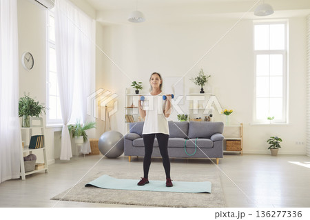 Active Senior Woman Exercising With Dumbbells At Home 136277336
