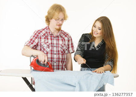 Man and woman couple ironing clothes 136277357