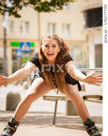 Young woman riding roller skates 136277399