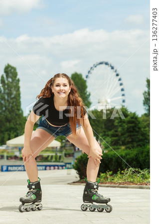 Young woman riding roller skates 136277403