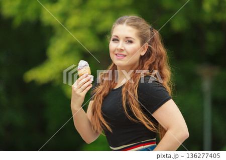 Young woman eating ice cream 136277405