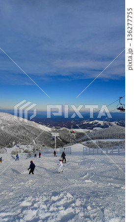 Skiers on snowy mountain slope 136277755