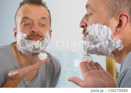 Guy shaving his beard in bathroom Guy shaving his beard in bathroom 136278080