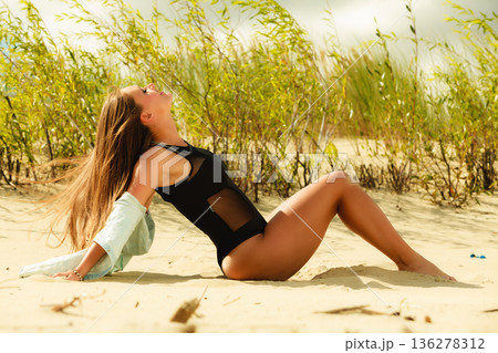 Young woman posing in grassy dune 136278312