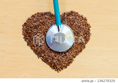 Raw flax seeds heart shaped and stethoscope Raw flax seeds heart shaped and stethoscope 136278320