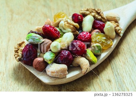Varieties of dried fruits and nuts on wooden spoon. Varieties of dried fruits and nuts on wooden spoon. 136278325