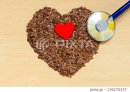 Raw flax seeds heart shaped and stethoscope Raw flax seeds heart shaped and stethoscope 136278337
