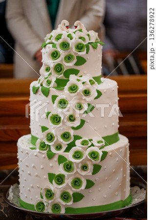 Elegant Three-Tier Wedding Cake with White and Green Fondant Roses and Swan Decorations 136278922