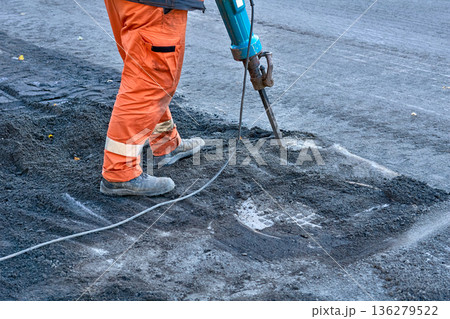 Hammer drill.Road worker breaks up old asphalt with jackhammer Hammer drill.Road worker breaks up old asphalt with jackhammer 136279522