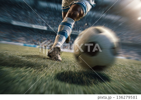 A football player kicks a ball hard close-up on the stadium pitch 136279581