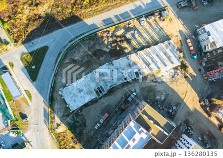 Workers are busy at construction site developing new buildings beside main road in growing area 136280135