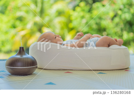 Newborn baby resting in a cozy cocoon beside mother with aroma lamp, calm home atmosphere. Infant relaxation, gentle care, motherhood routine, aromatherapy for babies and family wellbeing concept. Newborn baby resting in a cozy cocoon beside mother with aroma lamp, calm home atmosphere. Infant relaxation, gentle care, motherhood routine, aromatherapy for babies and family wellbeing concept. 136280168