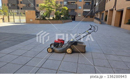 Lawn mower on pavement in urban residential area 136280943