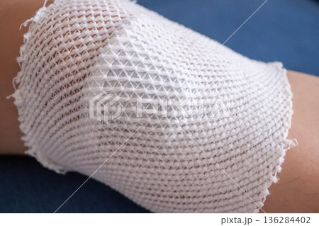 wound dressing bandage on child knee after fall on the ground 136284402