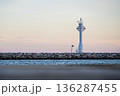 Minimal Lighthouse on Breakwater at Calm Sea and Pastel Sky 136287455