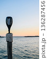 Outdoor Torch on Wooden Post by Sea at Sunset 136287456