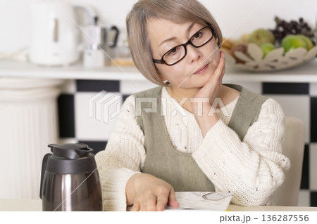 キッチンでカップ麺にお湯を入れるシニア女性 136287556