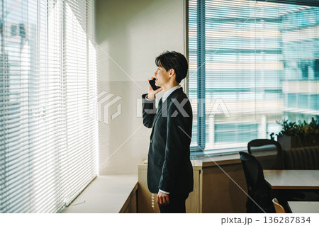 スマホで話す若いビジネスマン 136287834