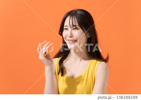 オレンジバックの笑顔の女性 136288289