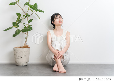 フローリングに座る笑顔の美しいアジア人女性（見上げる,考える,想像,妄想,プラン,計画） 136288785