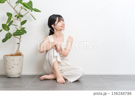 フローリングに座る笑顔の美しいアジア人女性（見上げる,考える,想像,妄想,プラン,計画） 136288786