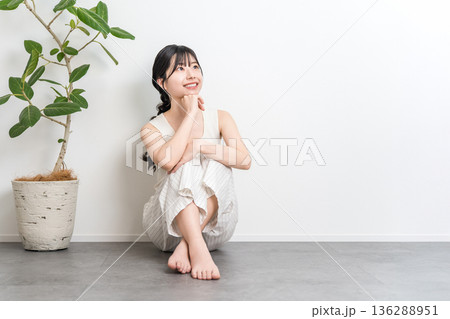 フローリングに座る笑顔の美しいアジア人女性（見上げる,考える,想像,妄想,プラン,計画） 136288951