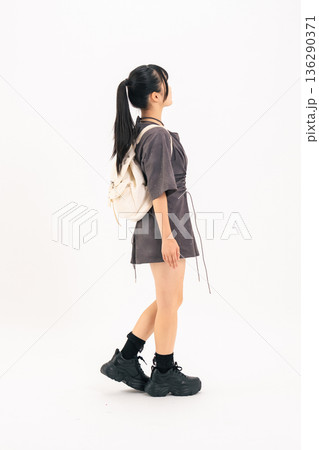 歩く10代の女性の後ろ姿の全身写真 136290371