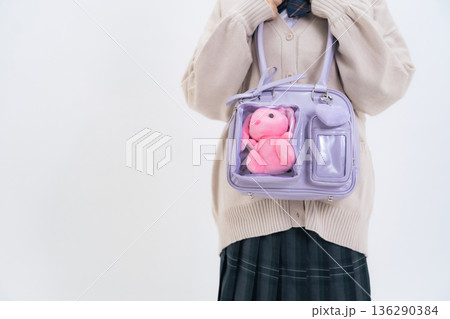 ぬいぐるみの入ったバッグを持った女子学生 136290384