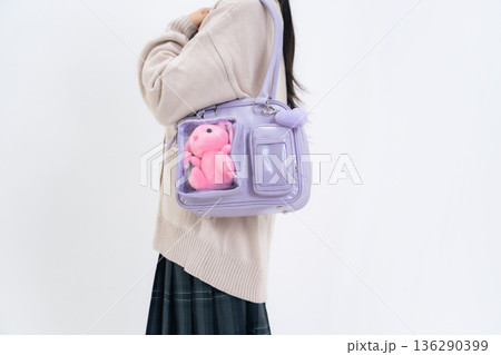 ぬいぐるみの入ったバッグを持った女子学生 136290399