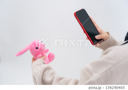 ぬいぐるみをスマホで撮影する女子学生 136290403