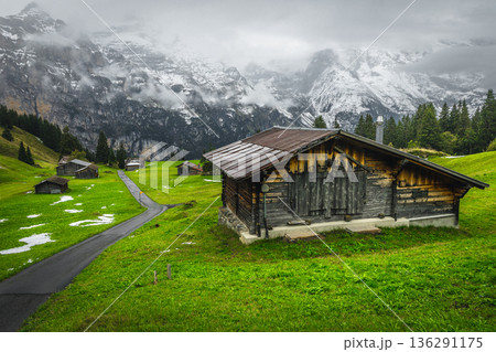 Wooden barns and foggy snowy mountain ridge in Switzerland Wooden barns and foggy snowy mountain ridge in Switzerland 136291175