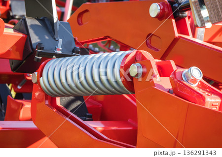 Steel silver spring as part of red heavy agricultural, industrial machine. Technology Steel silver spring as part of red heavy agricultural, industrial machine. Technology 136291343