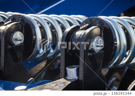 Steel silver spring as part of blue heavy agricultural, industrial machine. Technology 136291344
