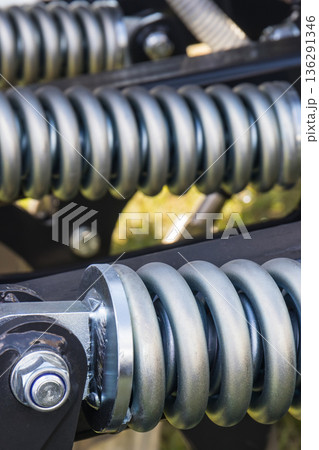 Steel silver spring as part of black heavy agricultural, industrial machine. Technology 136291346