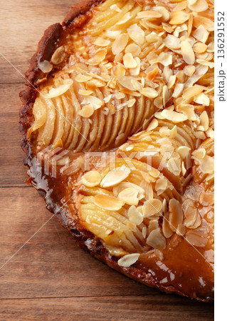 Fresh pear tart with almond slices on a wooden table 136291552