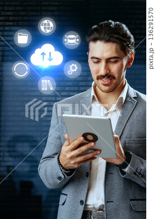 Businessman using tablet for cloud technology and data management in a modern office setup Businessman using tablet for cloud technology and data management in a modern office setup 136291570