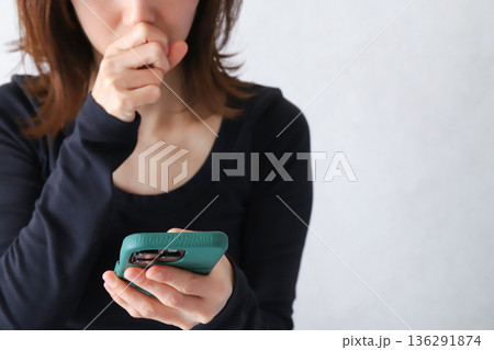スマホを見て驚く女性の手元 スマホを見て驚く女性の手元 136291874