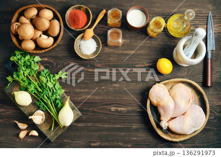 Raw chicken legs, mushrooms and vegetables - ingredients for cooking on wooden table with copy space 136291973