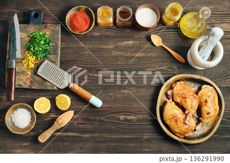 Cooking chicken with herbs and spices on a wooden table in a home kitchen 136291990