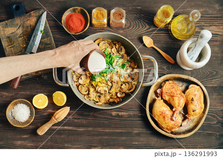 Pouring heavy cream to a pot filled with fried onion and mushrooms 136291993