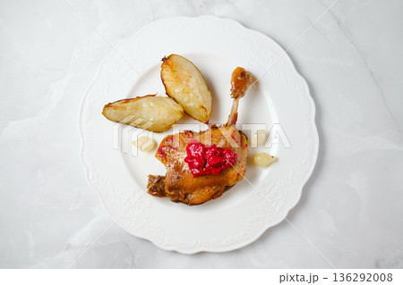 Enjoying duck confit served with roasted potatoes and sauce in a simple dining setup 136292008