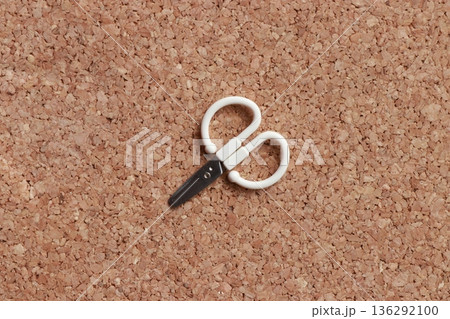 コルク背景に置かれた小さなハサミ 生活用品のミニマル素材写真 136292100
