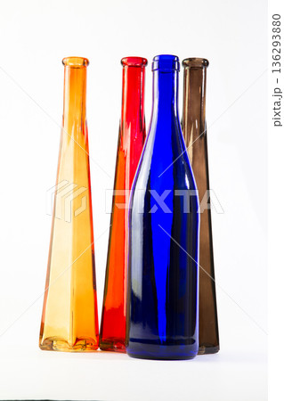 Still life of colored glass bottles on a white background 136293880