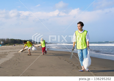 砂浜の清掃活動に取り組むボランティアスタッフの若者と仲間たち 136295202